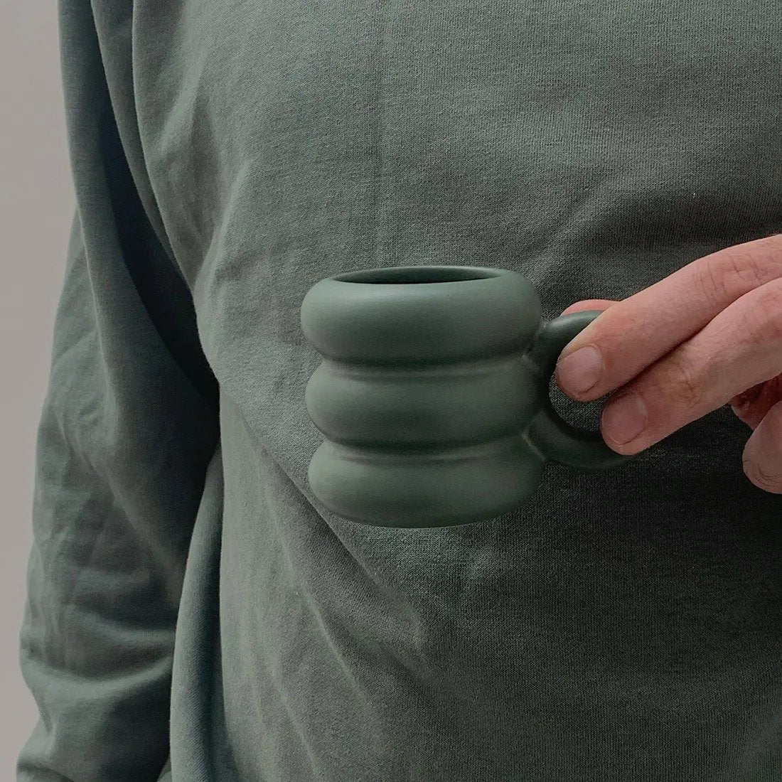 Mano sosteniendo mini mug.