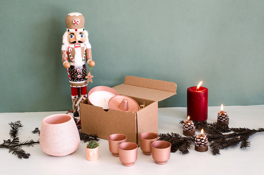 Imagen de caja con regalos navideños y un cascanueces. En los regalos estan los mezcaleros escalon rosa, la taza Xoco rosa y el pora inciensos Mariachi con la vela Spin